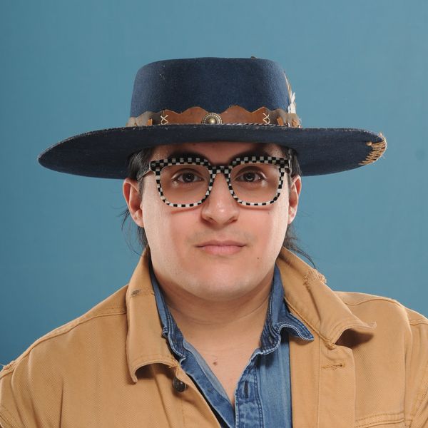 A patient of The Optical Centre in a cowboy hat and checkered frames